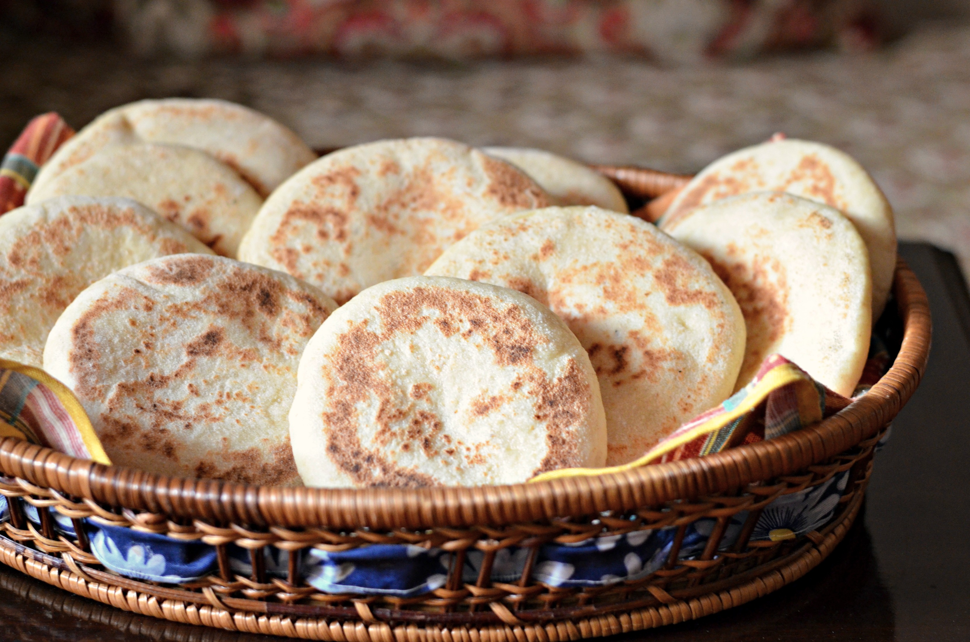 Photo of batbout, Moroccan pita bread, in a basket on a table.