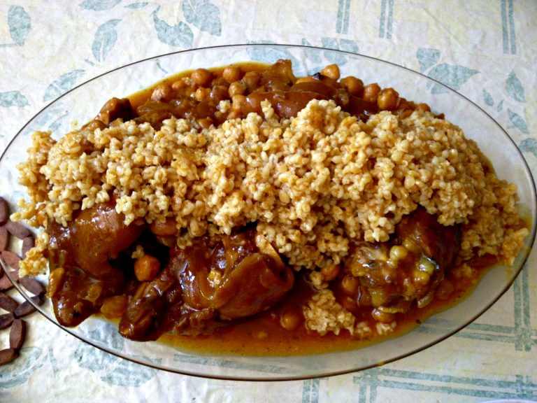 overhead image of a platter of Moroccan trotters and chickpeas topped by a garnish of wheat berries