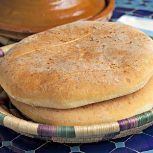 two loaves of Moroccan flatbread called khobz in a traditional basket