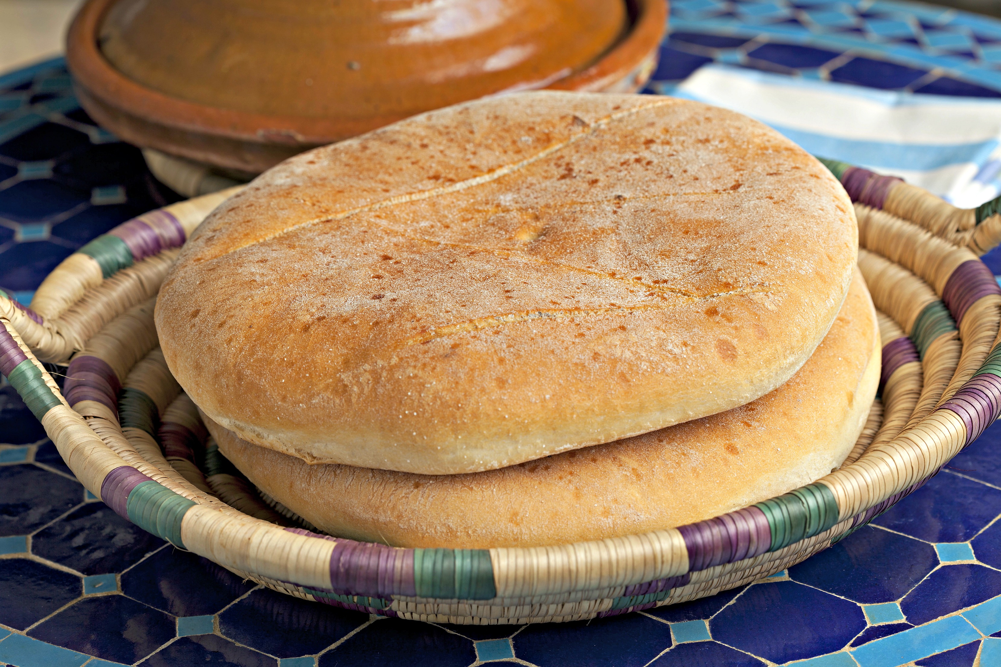 two loaves of Moroccan flatbread called khobz in a traditional basket