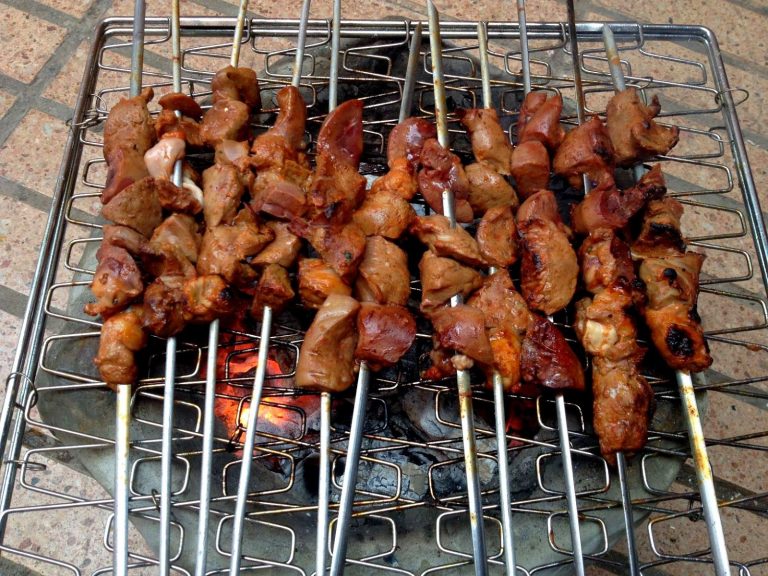 liver, heart and kidney brochettes cooking over charcoal