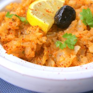 Moroccan cabbage Zaalouk, finely chopped texture, decorated with half a slice of lemon, a black olive and a few coriander leaves