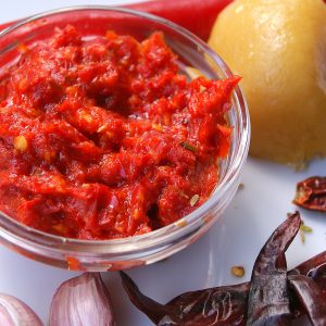 Harissa paste made with fresh cayenne peppers, surrounded by dried chili, garlic, preserved lemons and a fresh cayenne