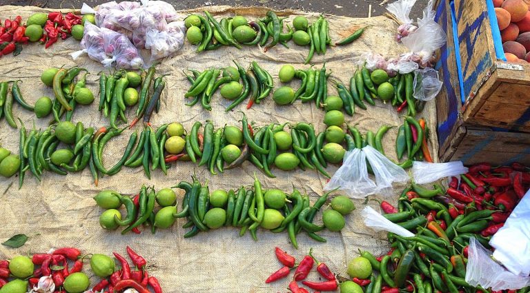 A spread of red and green chili , lime and garlic sold in the market., ideal for harissa