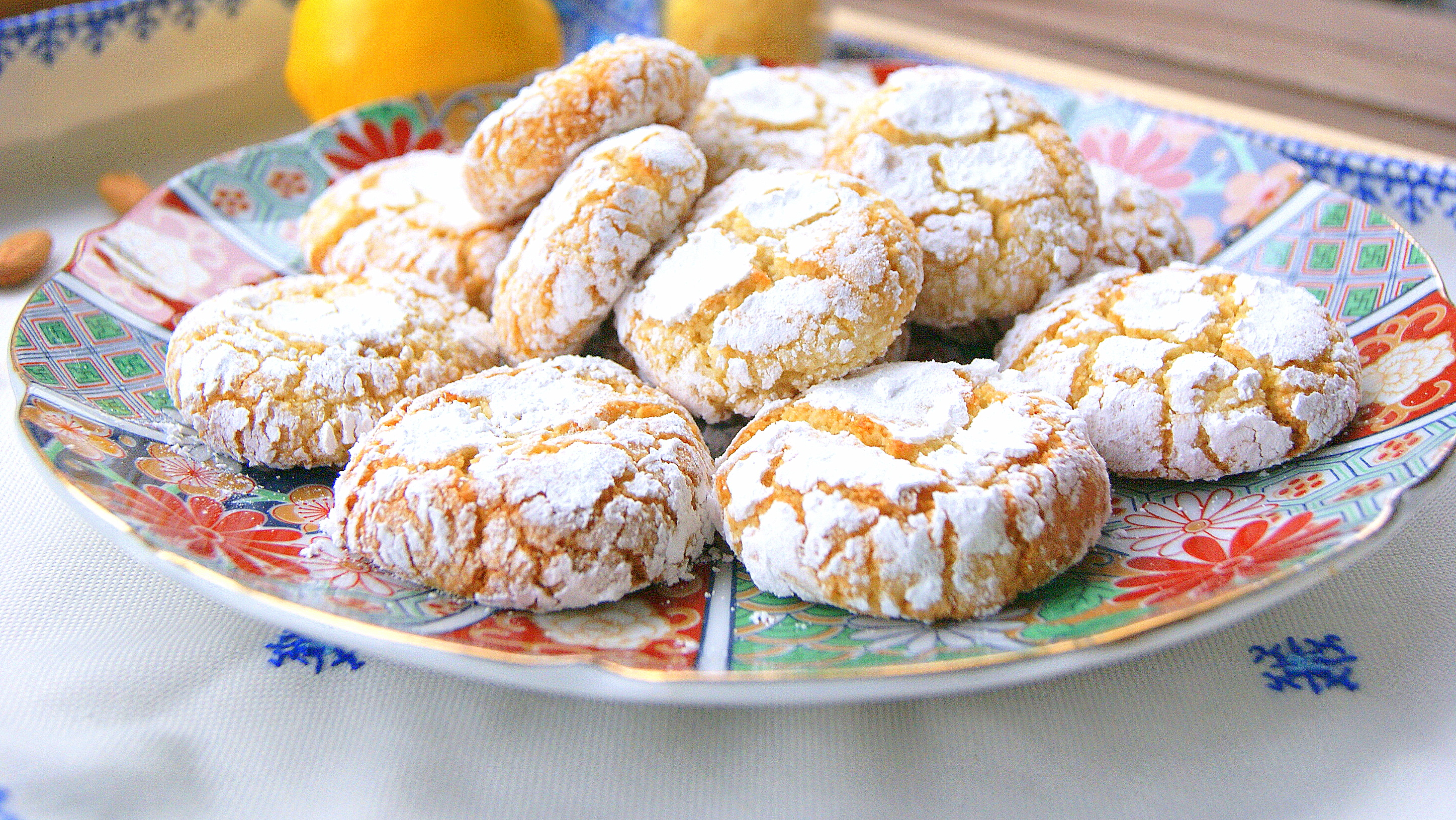 Moroccan almond ghrieba or macaroon on a plate. The cookies are chewy in texture with cracks on the surface. They are dusted with powdered sugar.