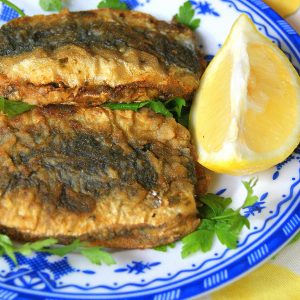 Moroccan coupled and fried sardines served over parsley leaves and served with lemon wedges