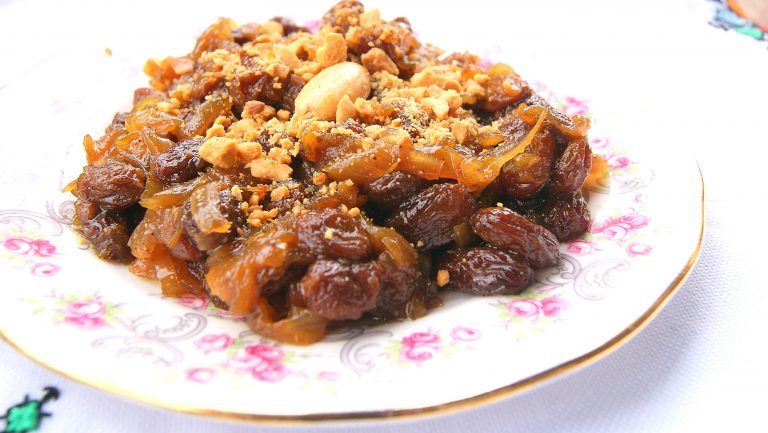 A close up photo of t'faya, a sweet confit of onions and raisin, topped with crushed almonds.