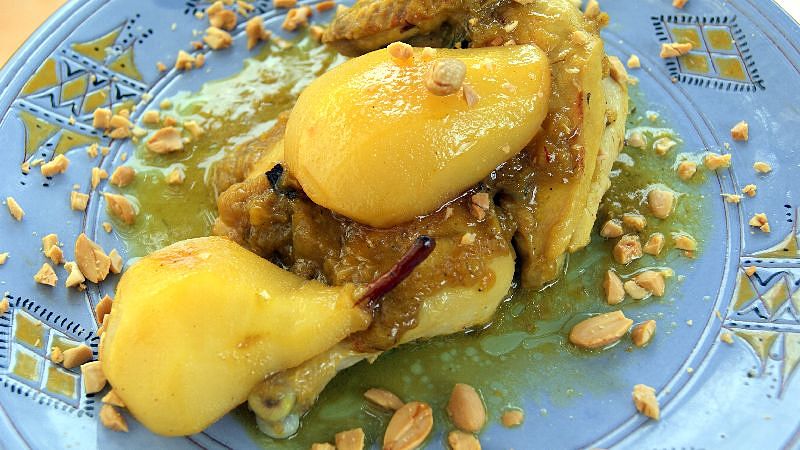 A serving of Moroccan chicken and caramelized pears garnished with fried almonds.