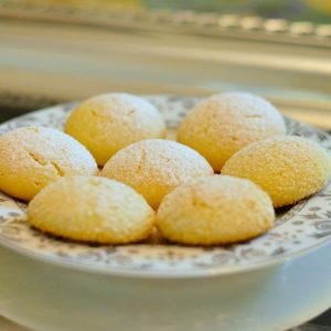 Close-up photo of seven cake-like cookies on a plate with silver floral etching.