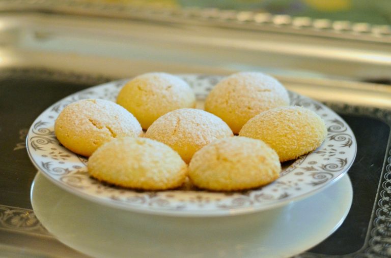 Close-up photo of seven cake-like cookies on a plate with silver floral etching.