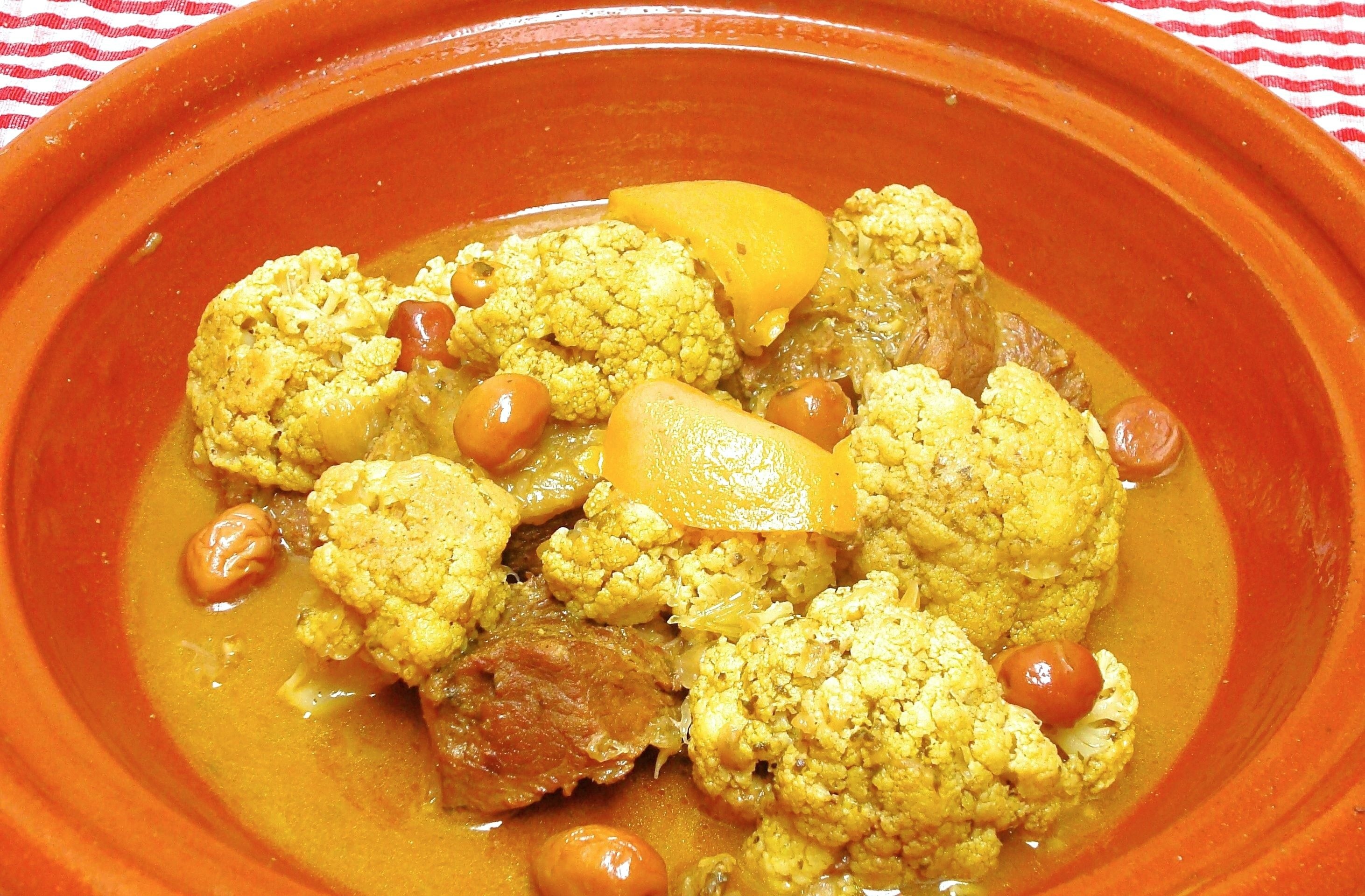 A Moroccan dish of beef and cauliflower with preserved lemon and olives in the base of a tagine.