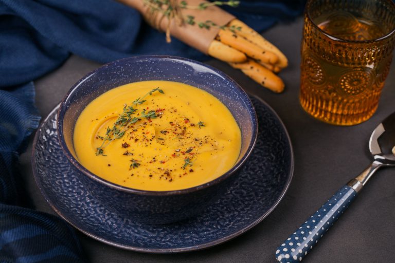 A bowl of pureed vegetable soup garnished with herbs